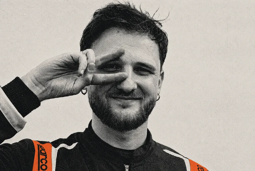Vit Panchuk in a racing suit, two fingers raised beside one eye